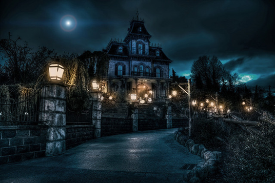 photo of Disneyland's Haunted Mansion at night looking creepy