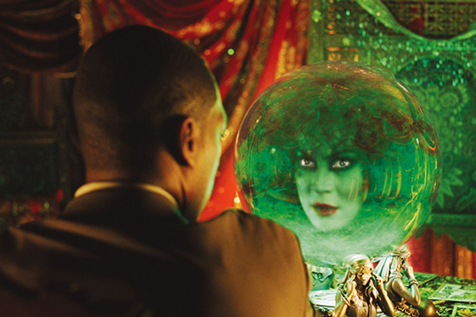 photo of Eddie Murphy looking at woman's face apparition in a crystal ball in photo of Disneyland's Haunted Mansion attaction