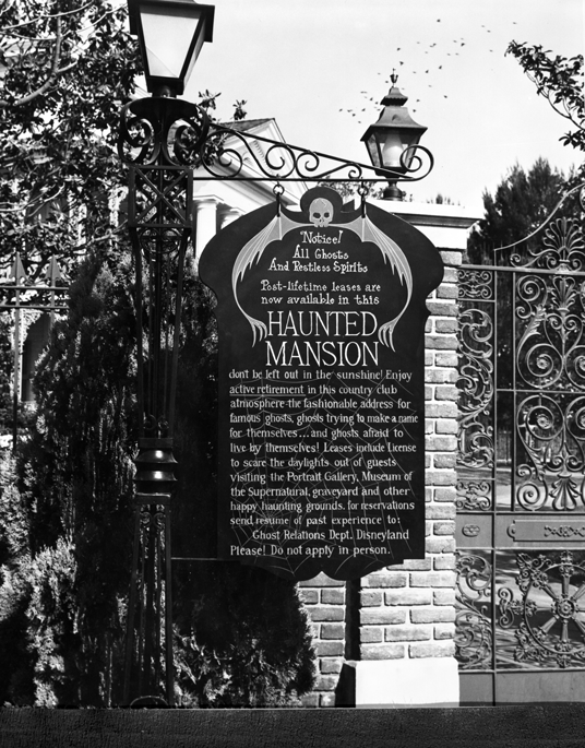 photo of sign posted at front gate of The Haunted Mansion begins with Notice! All Ghosts and Restless Spirits