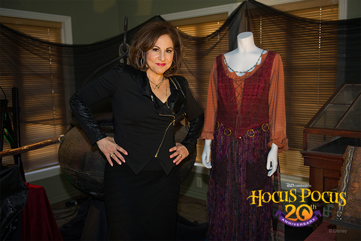 Actress Kathy Najimy (Mary Sanderson) poses next to her costume in the Walt Disney Archives display.