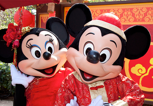 photo of smiling life-size Minnie Mouse and Mickey Mouse all dressed up in bright red
