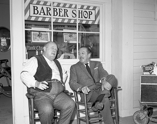 Burl Ives and Walt chat on the front porch of the Beulah barbershop.