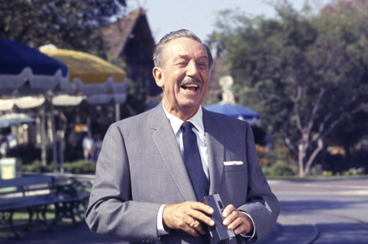 Walt Disney stands near the Central Plaza, ready to capture another gorgeous Disneyland day on film.