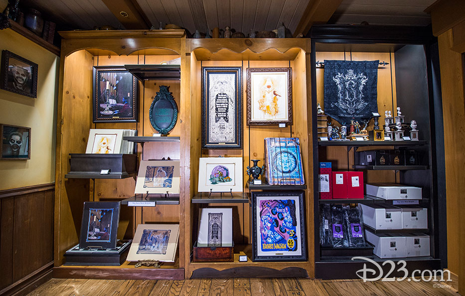 photo of merchandise displayed including framed illustrations based on Haunted Mansion