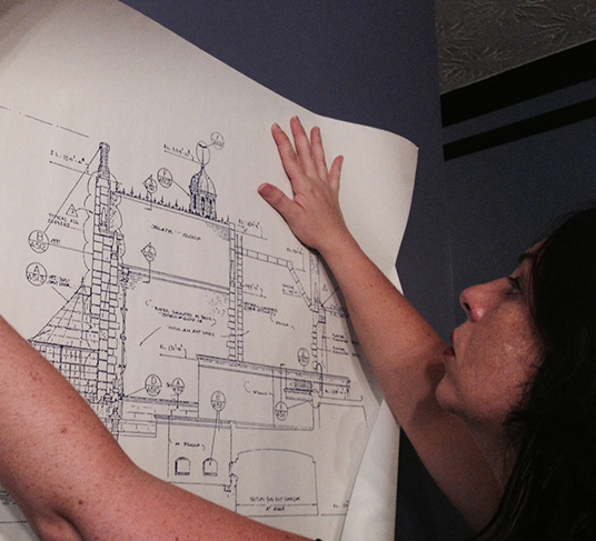 photo of Holly Frey holding up blueprint of Haunted Mansion