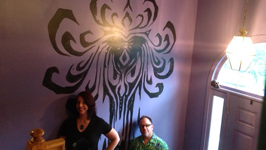 photo of Holly Frey and Brian Frey beside purple and black stairway wall at foyer