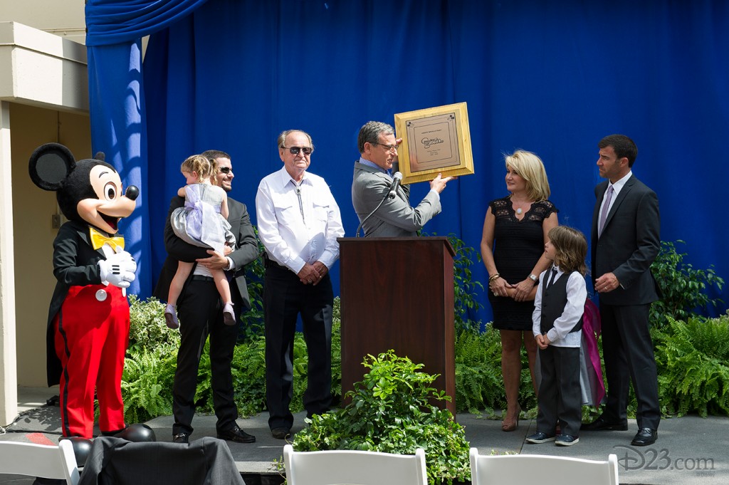 Disney Chairman and CEO Robert A. Iger displays the plaque commemorating the dedication while surrounded by Annette’s husband Glenn Holt, children, and grandchildren.