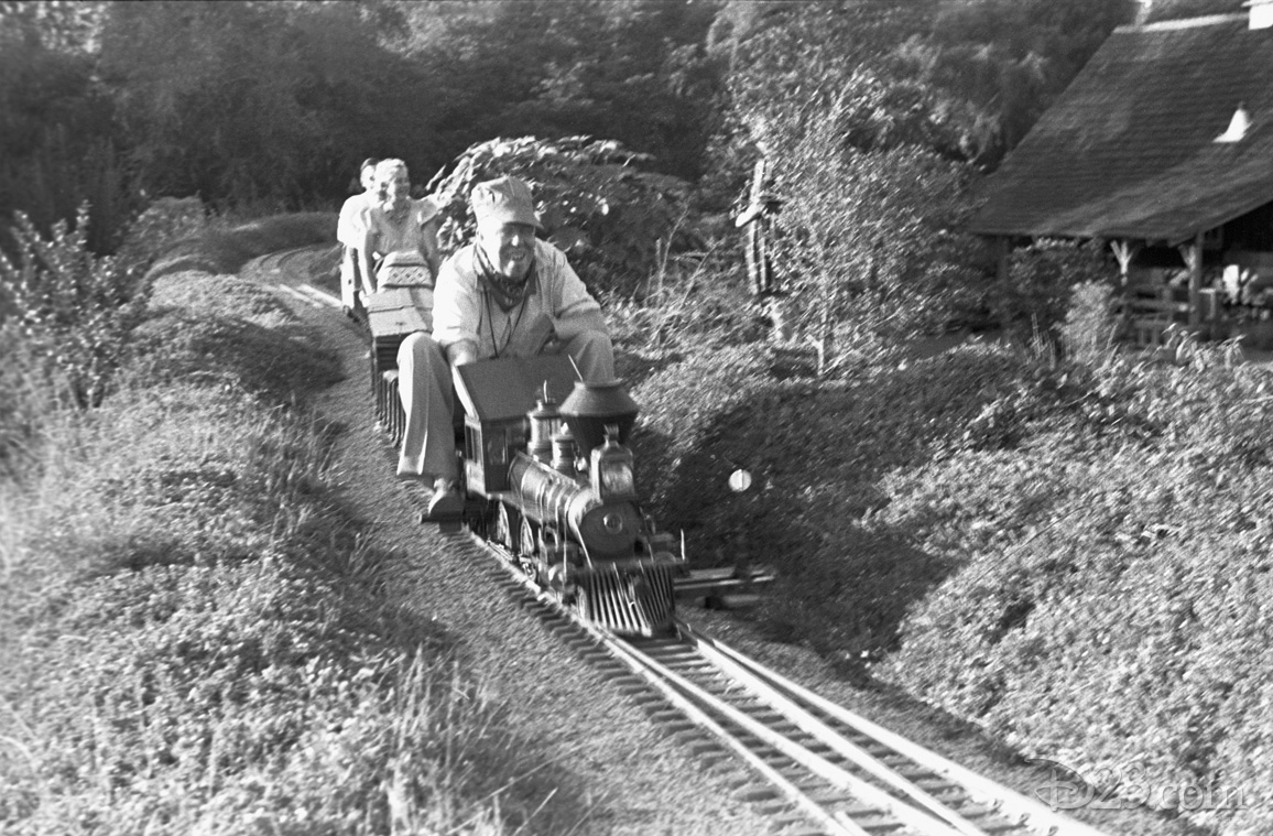One of Walt’s first Imagineers, Harper Goff—a fellow model train enthusiast—seen behind the Lilly Belle steam engine as it powers the <i>Carolwood Pacific</i> on another lap around Walt’s Carolwood Drive home.