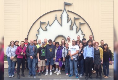 D23 Members standing by the Disney mural at the Walt Disney Studio Lot