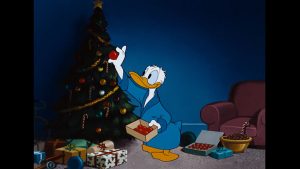 Donald Duck placing an ornament on the Christmas tree