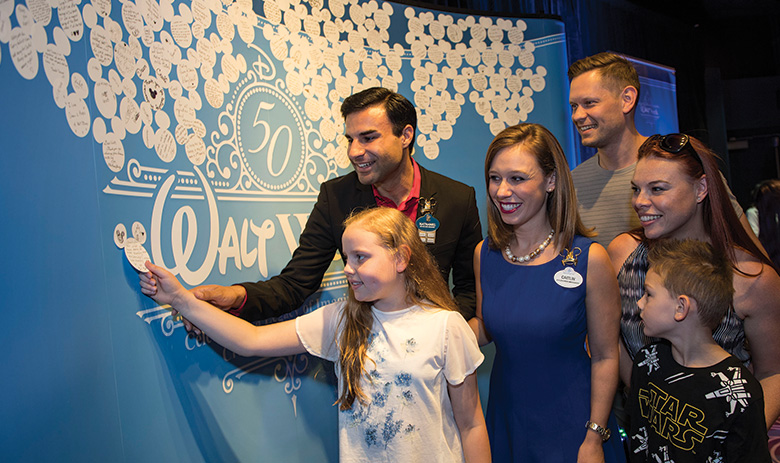 A guest places a memory on a Walt Disney memory board