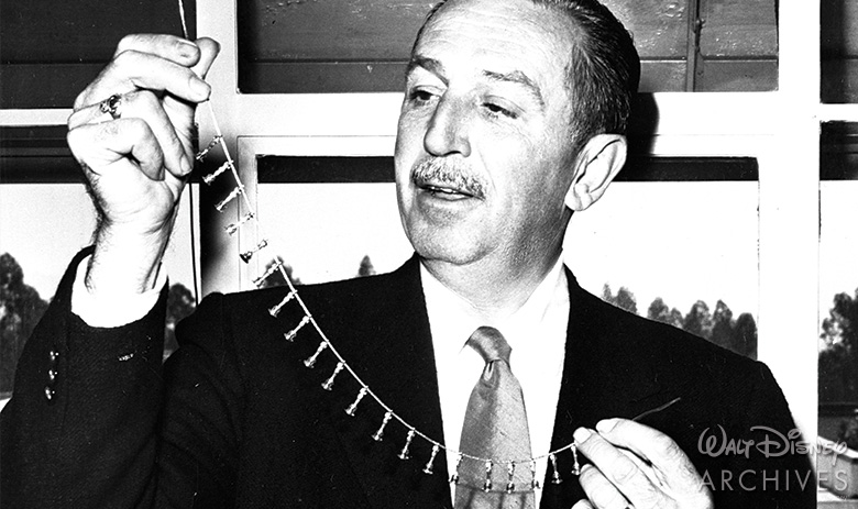 Walt Disney holding his Oscar charm necklace