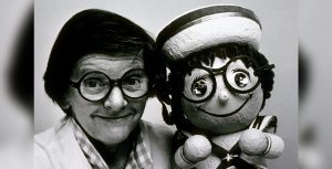 Joyce Carlson with posing with a remarkably similar “it’s a small world” doll.