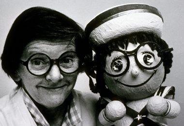 Joyce Carlson with posing with a remarkably similar “it’s a small world” doll.