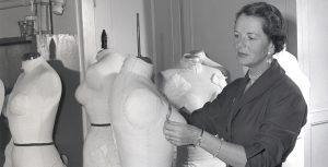 Renié measuring a female dress form.