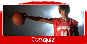 Troy Bolton, played by Zac Efron, from High School Musical, holds out a basketball to the side with his right hand. A dramatic light and smoke illuminate him from behind. There is a red semi circle behind the picture, with the curved part coming up just above the picture, and text reads “D23 Quiz” under the picture.