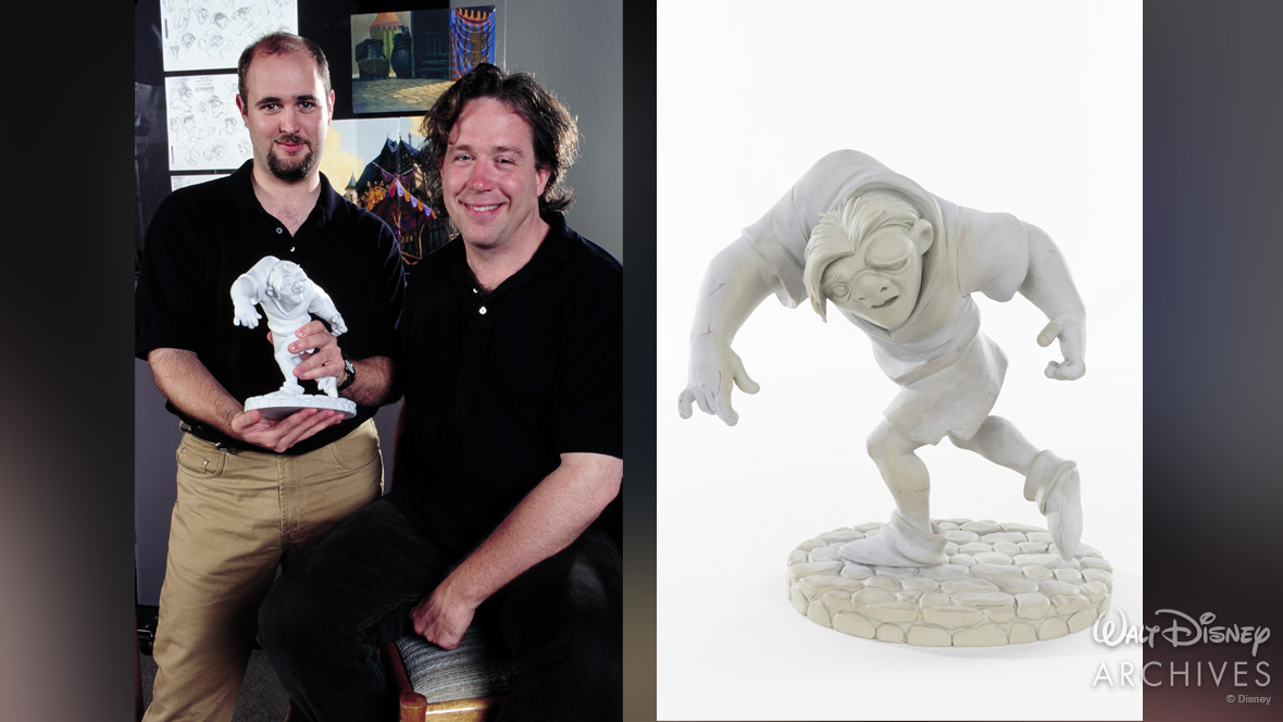 Supervising animator James Baxter with Quasimodo&rsquo;s voice artist, Tom Hulce, pose together, both wearing black shirts, and one holding a sculpted maquette of Quasimodo on a stone base. The right side shows a close-up of the same style maquette.