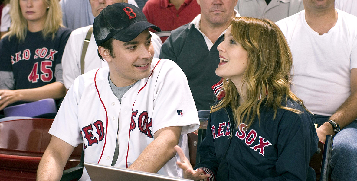 Jimmy Fallon (left) and Drew Barrymore (right), who has her laptop at the baseball game, talk during a scene in Fever Pitch.
