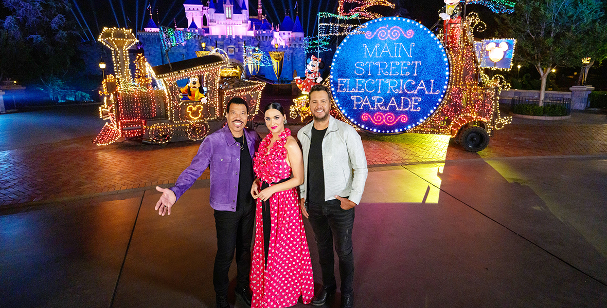 Judges Lionel Richie, Katy Perry, and Luke Bryan pose in front of Sleeping Beauty’s Castle at Disneyland Resort during a taping for Disney Night for American Idol.