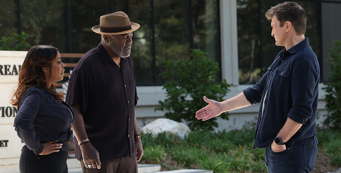 Niecy Nash, Frankie Faison, and Nathan Fillion talk outside of the police station during an episode of The Rookie.