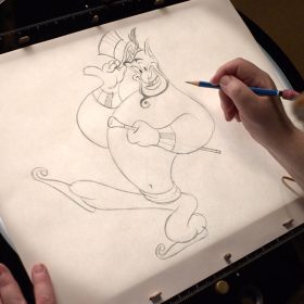An artist draws Genie with pencil on see-through paper.