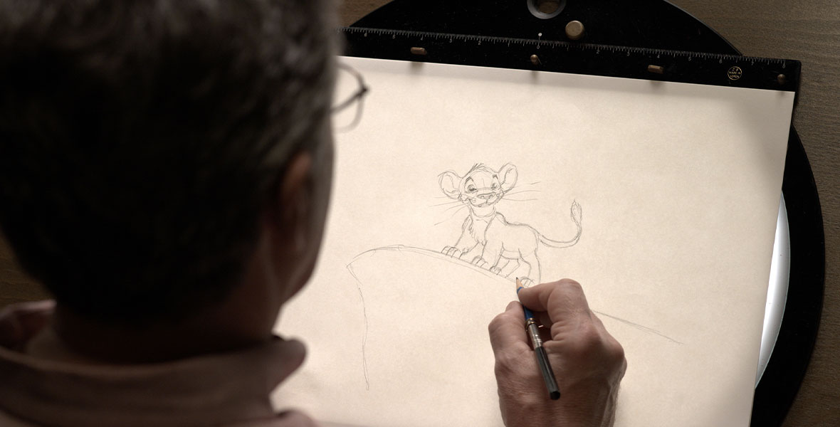 An artist draws young Simba from The Lion King.