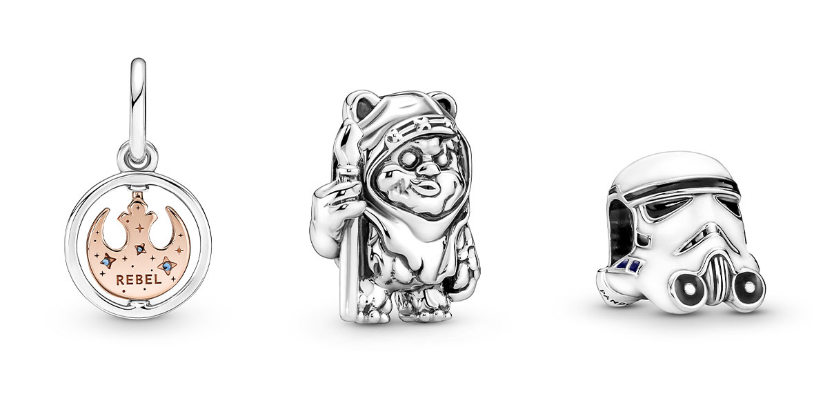 A collage of three Star Wars PANDORA Jewelry charms, including the Rebel Alliance symbol (in gold surrounded by a silver circle); a silver Ewok; and a silver and white Storm Trooper helmet.