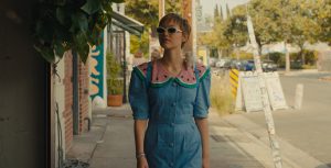 Grace VanderWaal as Stargirl Caraway walks down a street in Los Angeles with her pet rat on her shoulder in Disney's live-action Hollywood Stargirl.