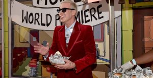 John Roberts, who voices Linda Belcher for the animated TV series and film, grabs an Impossible Burger as he walks the red carpet at the world premiere of The Bob’s Burgers Movie.
