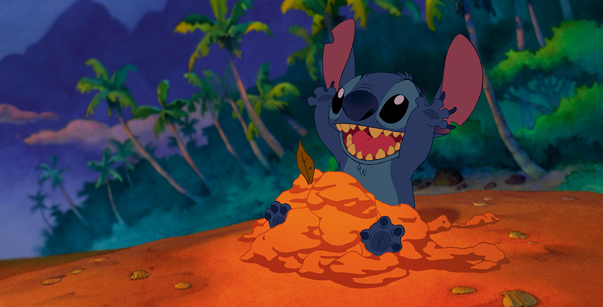 Stitch (voiced by Chris Sanders) plays in the sand in the animated film Lilo & Stitch.