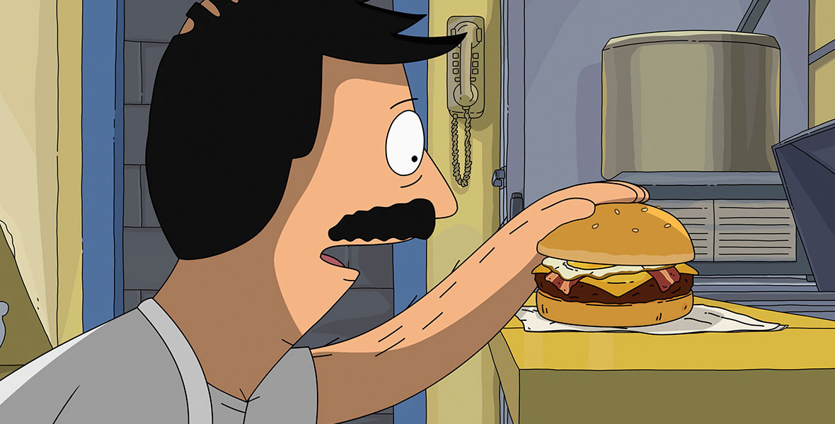 Bob Belcher (voiced by H. Jon Benjamin) gazes at a burger in his kitchen at Bob’s Burgers in 20th Century Studios’ The Bob’s Burgers Movie.