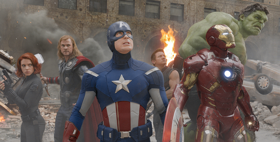 Black Widow, Iron Man, Captain America, Hawkeye, Hulk, and Thor stand in a circle while fighting in an image from Marvel Studios’ The Avengers.