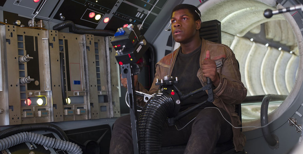 Finn sits at one of the gun stations on the Millennium Falcon, focused on defending the ship. He wears the black body glove of a Stormtrooper with Poe Dameron’s tan Resistance jacket over it.