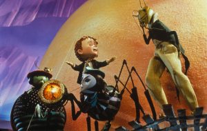 James stands in front of the enormous giant peach with Mr. Grasshopper, Mrs. Ladybug, and Miss Spider.