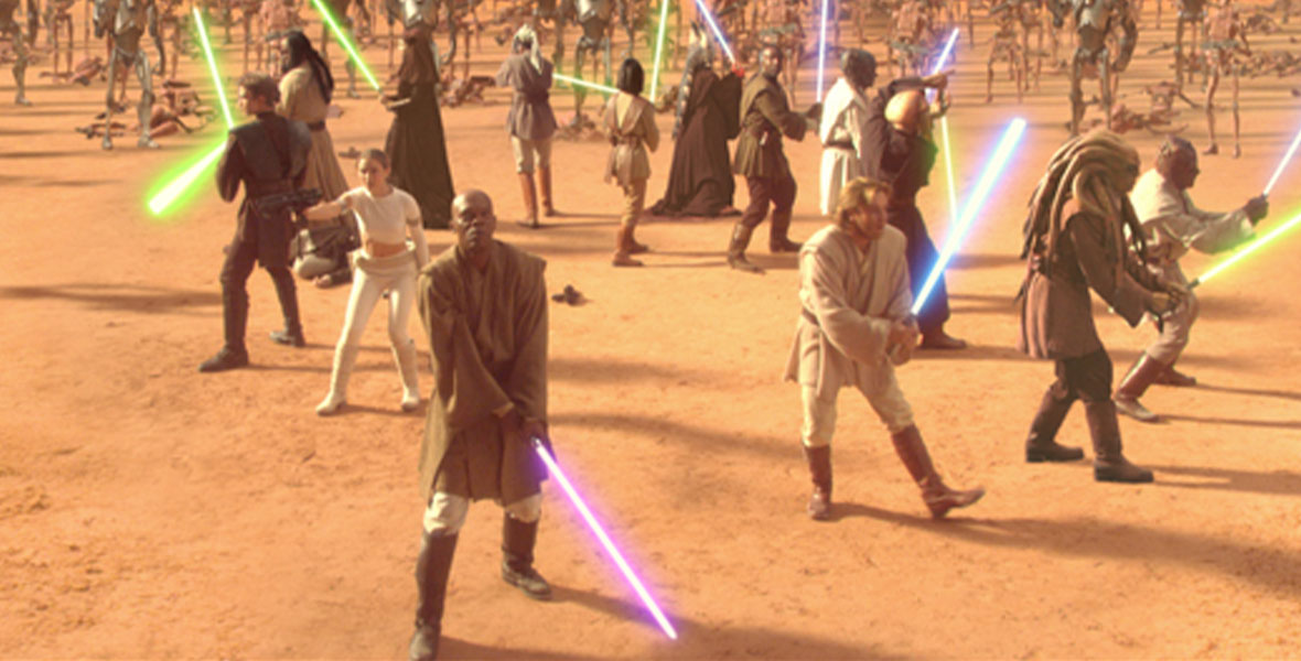 Anakin Skywalker, Padmé Amidala, Mace Windu, Obi-Wan Kenobi, and more Jedi stand in a defensive circle, surrounded by super battle droids during the Battle of Geonosis in Star Wars: Attack of the Clones