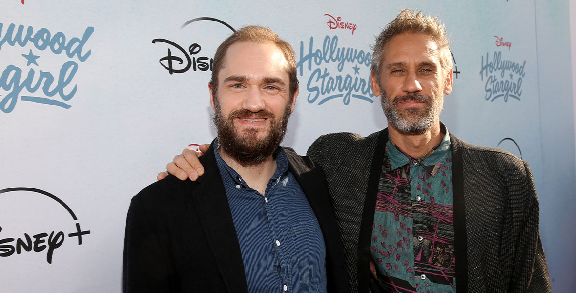 Co-composers Duncan Blickenstaff and Rob Simonsen. Blickenstaff is wearing a blue button-up shirt and black blazer. Simonsen has on an artistically patterned button-up and textured gray blazer with black trim.