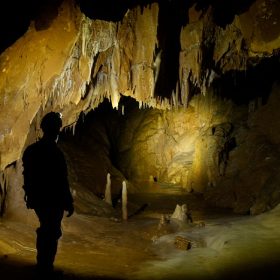 A team member lights up the cavern in front of him, deep beneath the Cheve Cave’s entrance.
