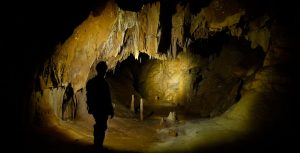 A team member lights up the cavern in front of him, deep beneath the Cheve Cave’s entrance.