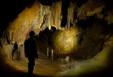 A team member lights up the cavern in front of him, deep beneath the Cheve Cave’s entrance.