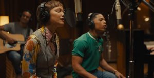Left to right: Grace VanderWaal as Stargirl Caraway and Elijah Richardson as Evan sing in a recording studio in Disney’s live-action film Hollywood Stargirl.