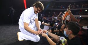 Pedro Pascal kneels on stage to sign an autograph for a fan at Star Wars Celebration