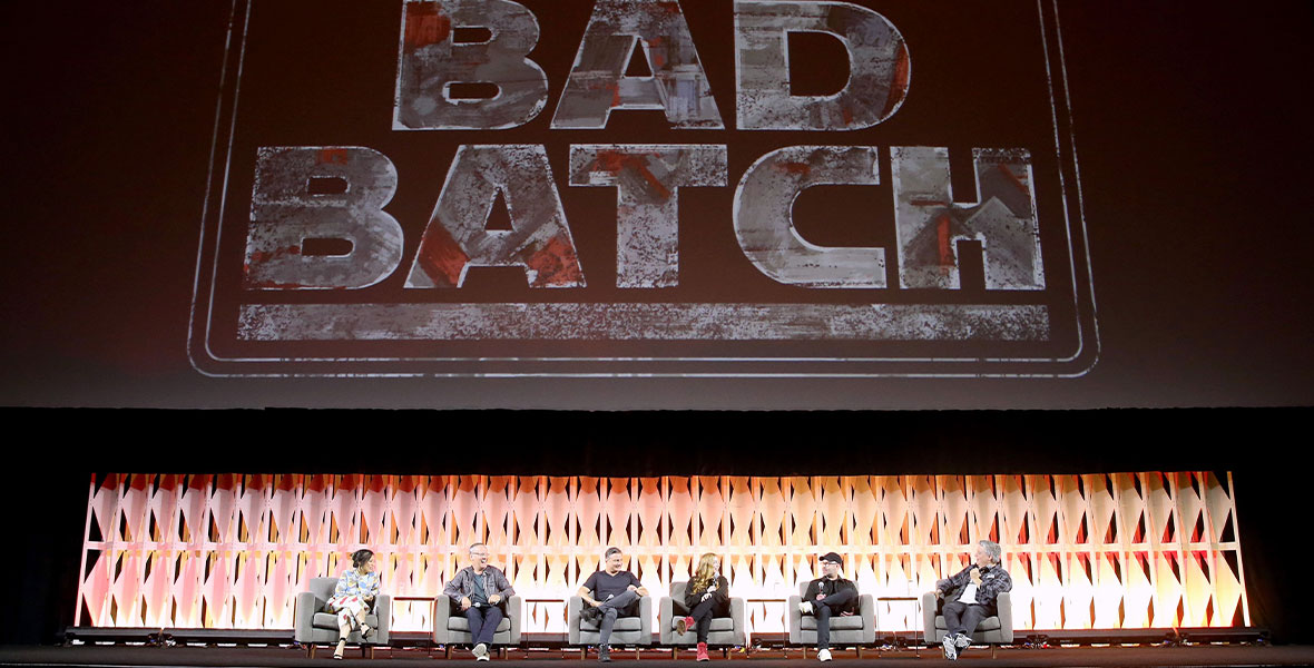 Star Wars: The Bad Batch supervising director Brad Rau, executive producer and head writer Jen Corbett, story editor Matt Michnovetz, and voice actors Dee Bradley Baker and Michelle Ang sit onstage in front of a screen with the Star Wars: The Bad Batch logo at Star Wars Celebration