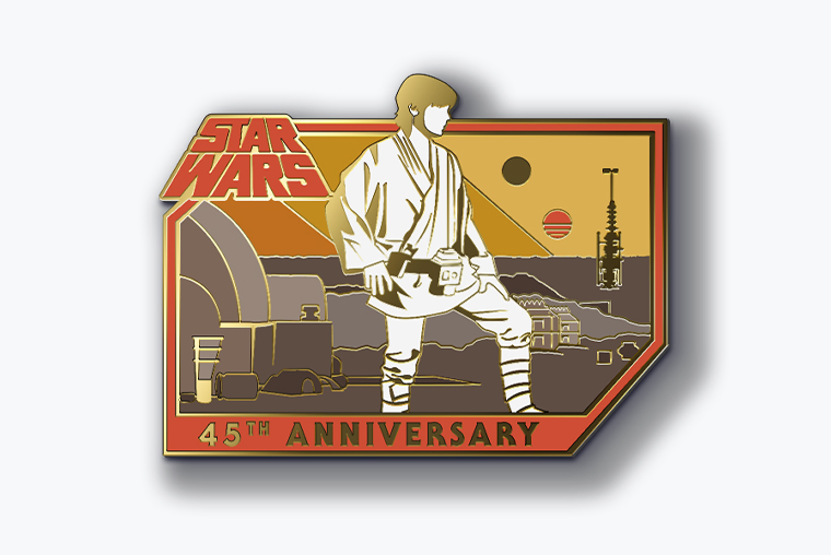 A pin featuring an illustration of Luke Skywalker standing in front of the Lars Homestead on Tatooine, watching the setting of the twin suns. The illustration is bordered in red, with the Star Wars logo and “45th anniversary” accompanying it.