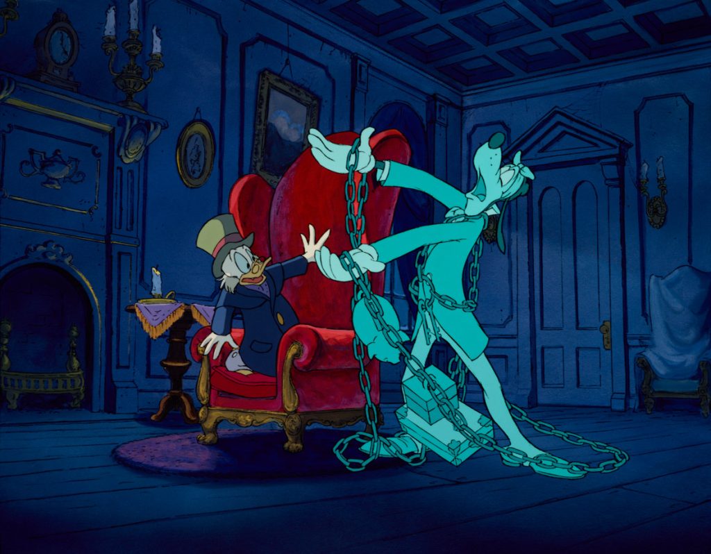 Goofy, as Jacob Marley’s ghost, is faded in color and wrapped in chains, in a still from Mickey’s Christmas Carol. He’s standing in Ebenezer Scrooge’s living room, next to a frightened Ebenezer, portrayed by Scrooge McDuck.