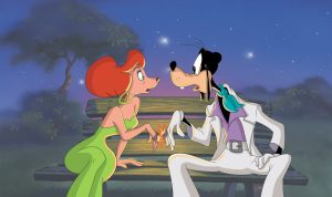 Sylvia and Goofy sit on a bench outside, at night, in a still from An Extremely Goofy Movie. Sylvia has red hair and is wearing a green strapless dress with green earrings; Goofy is wearing a white leisure suit with a purple shirt and green neck scarf. Their mood rings are touching and setting off a spark.