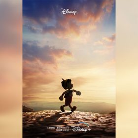 The teaser poster for Disney’s live-action Pinocchio features a silhouette of the puppet walking along a stone path—set against a pink and blue sky filled with wispy clouds, with some hills in the background.