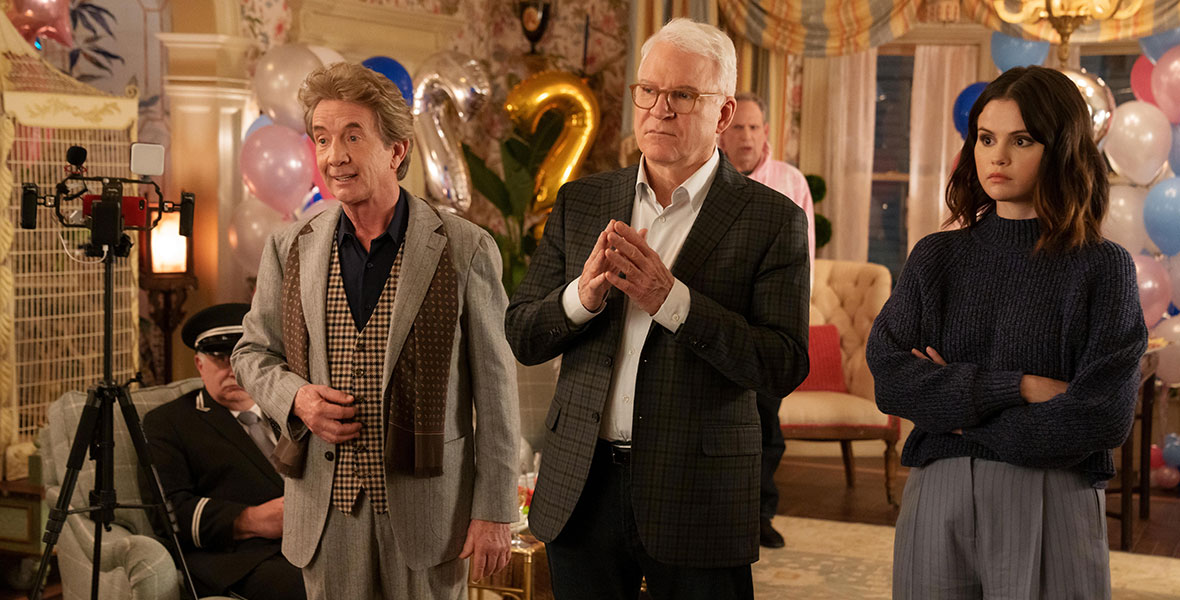 (L-R) Oliver (Martin Short), Charles (Disney Legend Steve Martin), and Mabel (Selena Gomez) stand in an apartment living room bewildered and surrounded by pastel-colored balloons in Only Murders in the Building.
