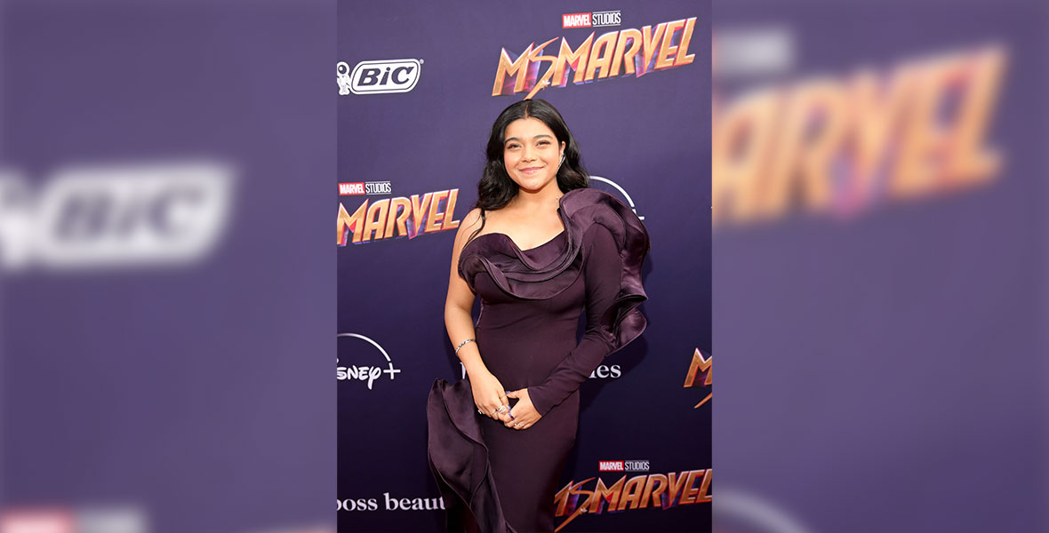Iman Vellani, who plays the titular role in the new live action series Ms. Marvel, poses in a purple, one-shoulder, ruffled gown, outside of the El Capitan Theatre