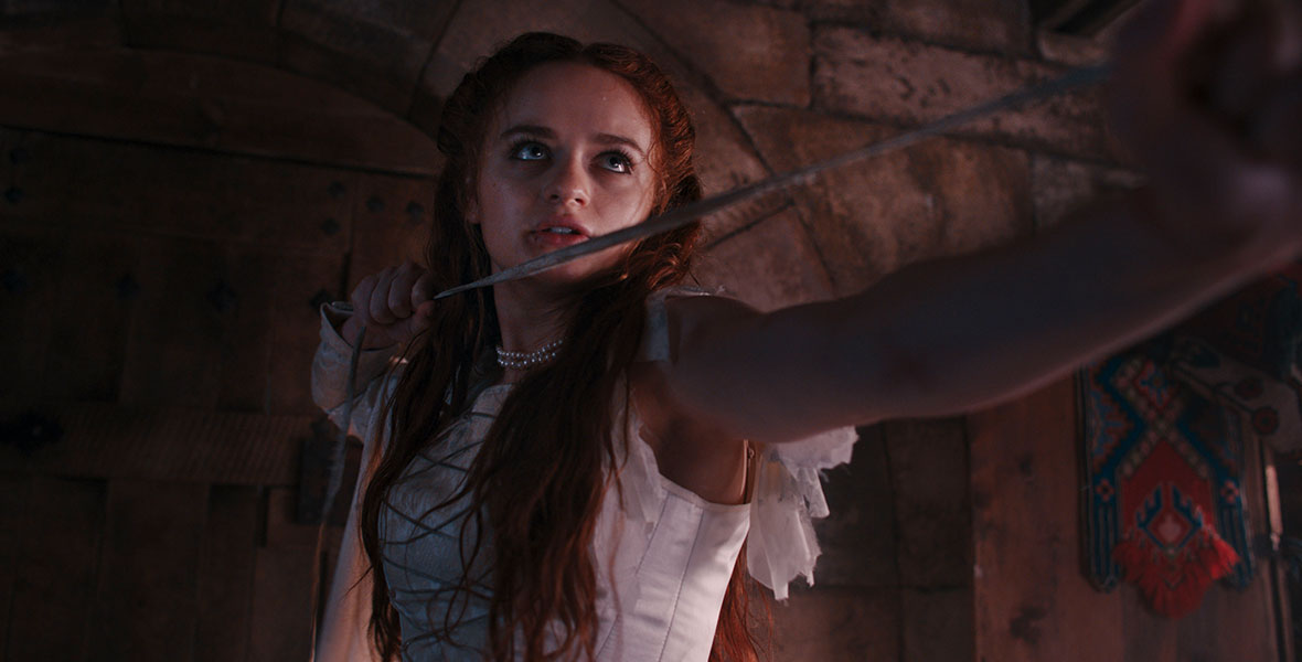 Joey King, who stars in the title role of The Princess, holding a large rope while fighting a guard. 