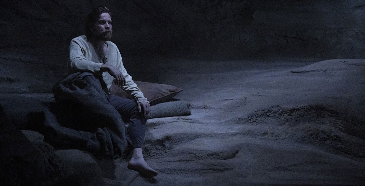 Obi-Wan Kenobi (Ewan McGregor) sits on a rock in Lucasfilm’s Obi-Wan Kenobi